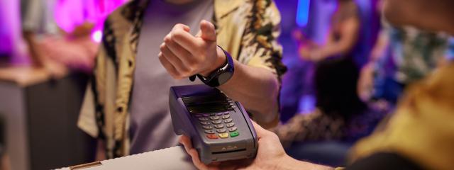 A young person using their smart watch to pay for pizza delivery