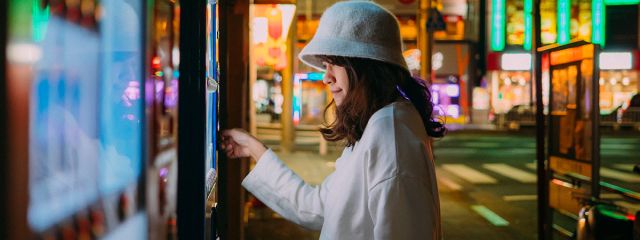 Person paying at a self service terminal on a city street