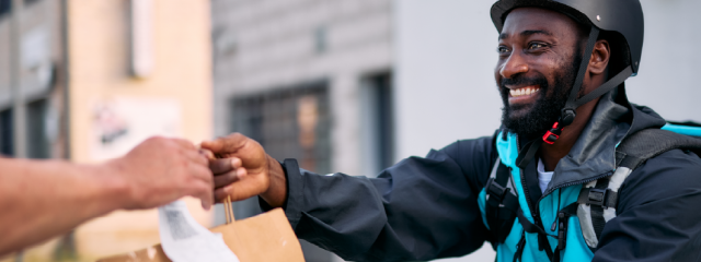 Food delivery worker handing off a delivery to a customer.